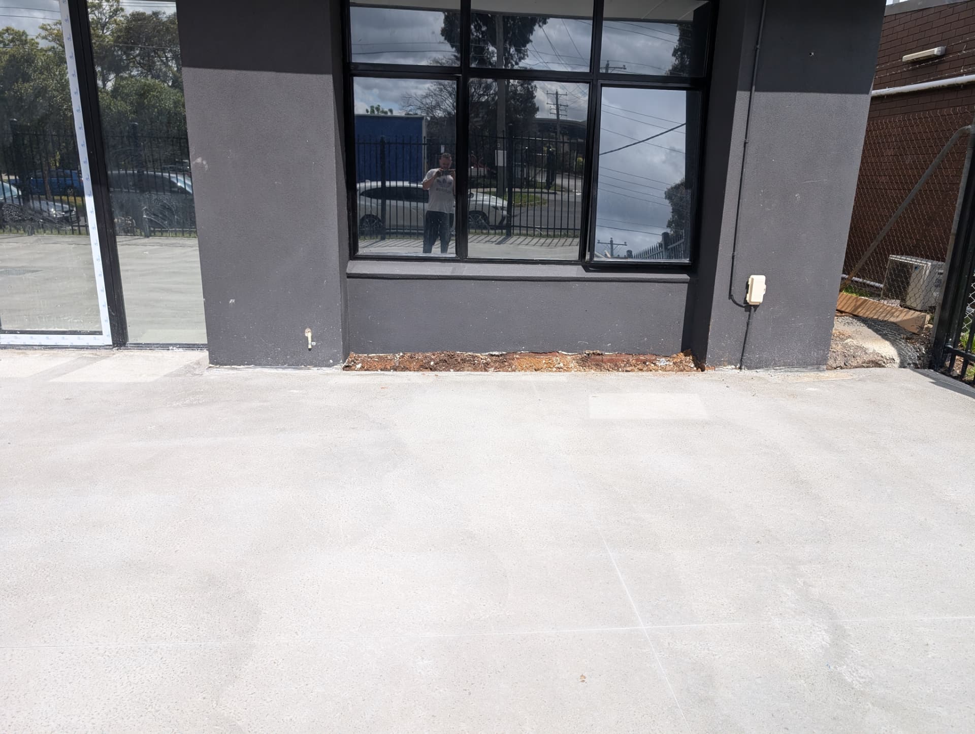 Freshly resurfaced smooth concrete slab outside a commercial shopfront